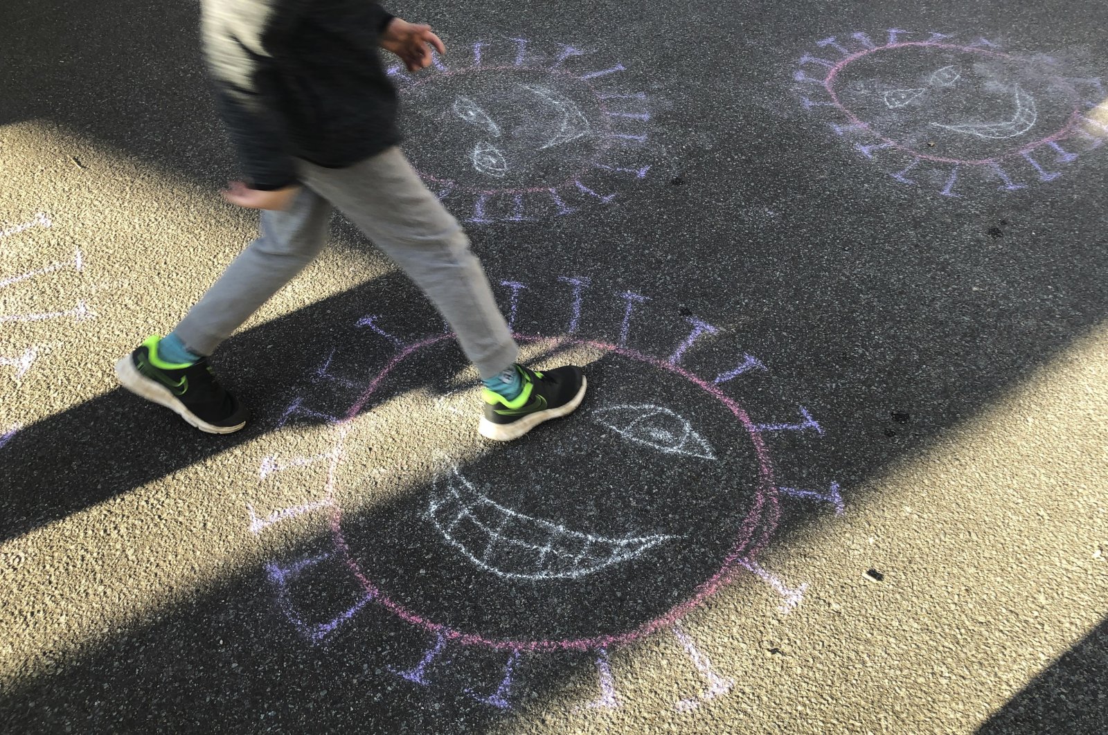 An artistic crayon depiction of the coronavirus painted by children on a street in Berlin, Germany, April 14, 2020. (AP Photo)