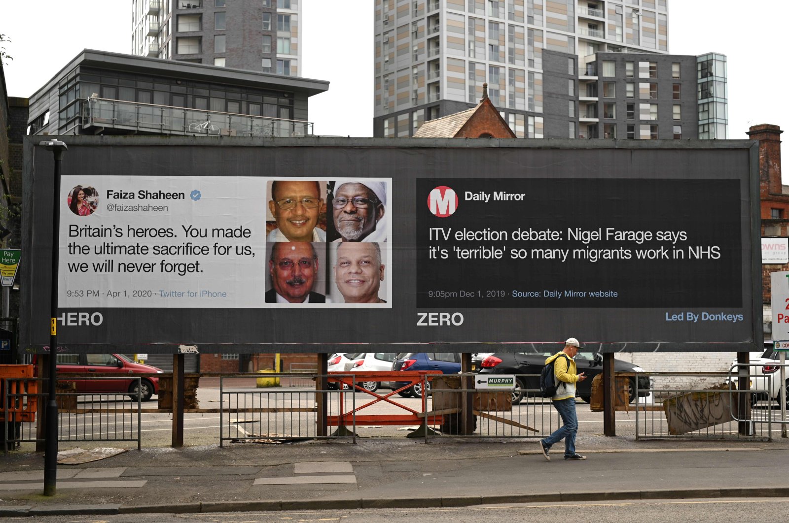 A man passes posters critical of comments made by Brexit Party leader Nigel Farage during the nationwide lockdown to combat the novel coronavirus pandemic in a near-deserted Manchester, England, April 12, 2020. (AFP Photo) 