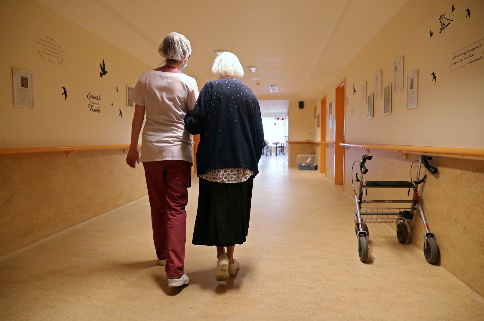 An occupational therapist walks with a woman of the elderly residence Christalain, Brussels, April 14, 2020. (REUTERS Photo)