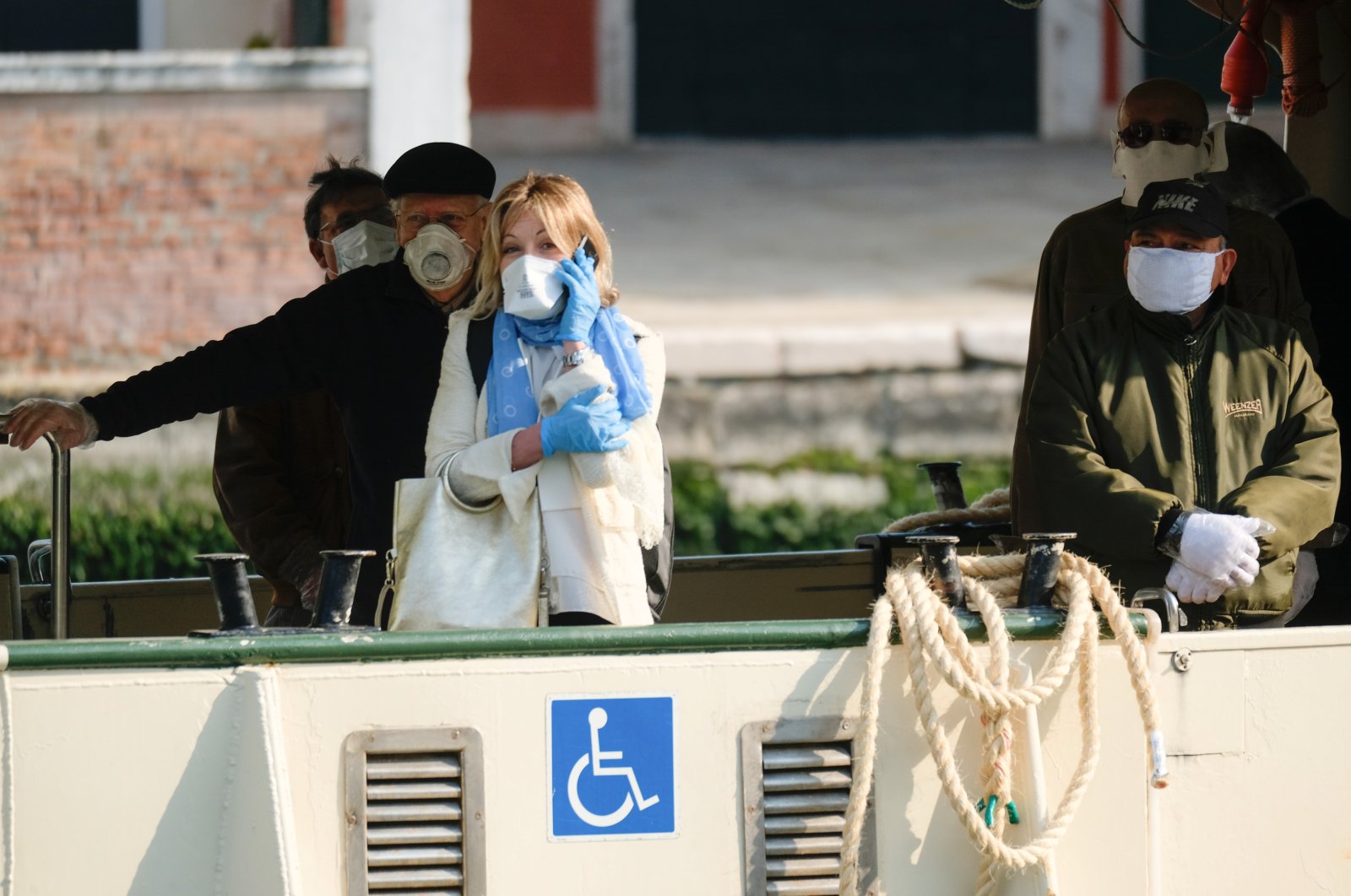People wearing protective masks and gloves are seen on a water bus as the Italian government allows the reopening of some shops while a nationwide lockdown continues, Venice, April 14, 2020. (REUTERS Photo)
