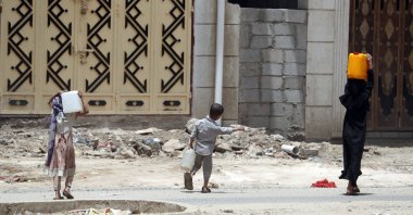 Yemeni children carry water-full bottles after filling them from a charity tap amid concerns over the spread of the coronavirus COVID-19, in Sanaa, Yemen, April 5, 2020. (EPA Photo)