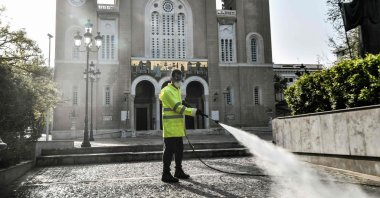 A municipal worker disinfects the forecourt outside Athens Metropolitan Church, Athens, Greece, April 15, 2020. (AFP Photo)