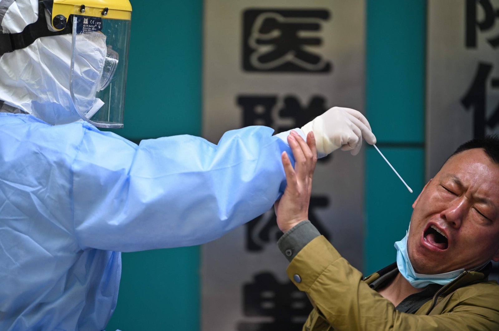 A man being tested for COVID-19 reacts as a medical worker takes a swab sample, in Wuhan, China, April 16, 2020. (AFP Photo)