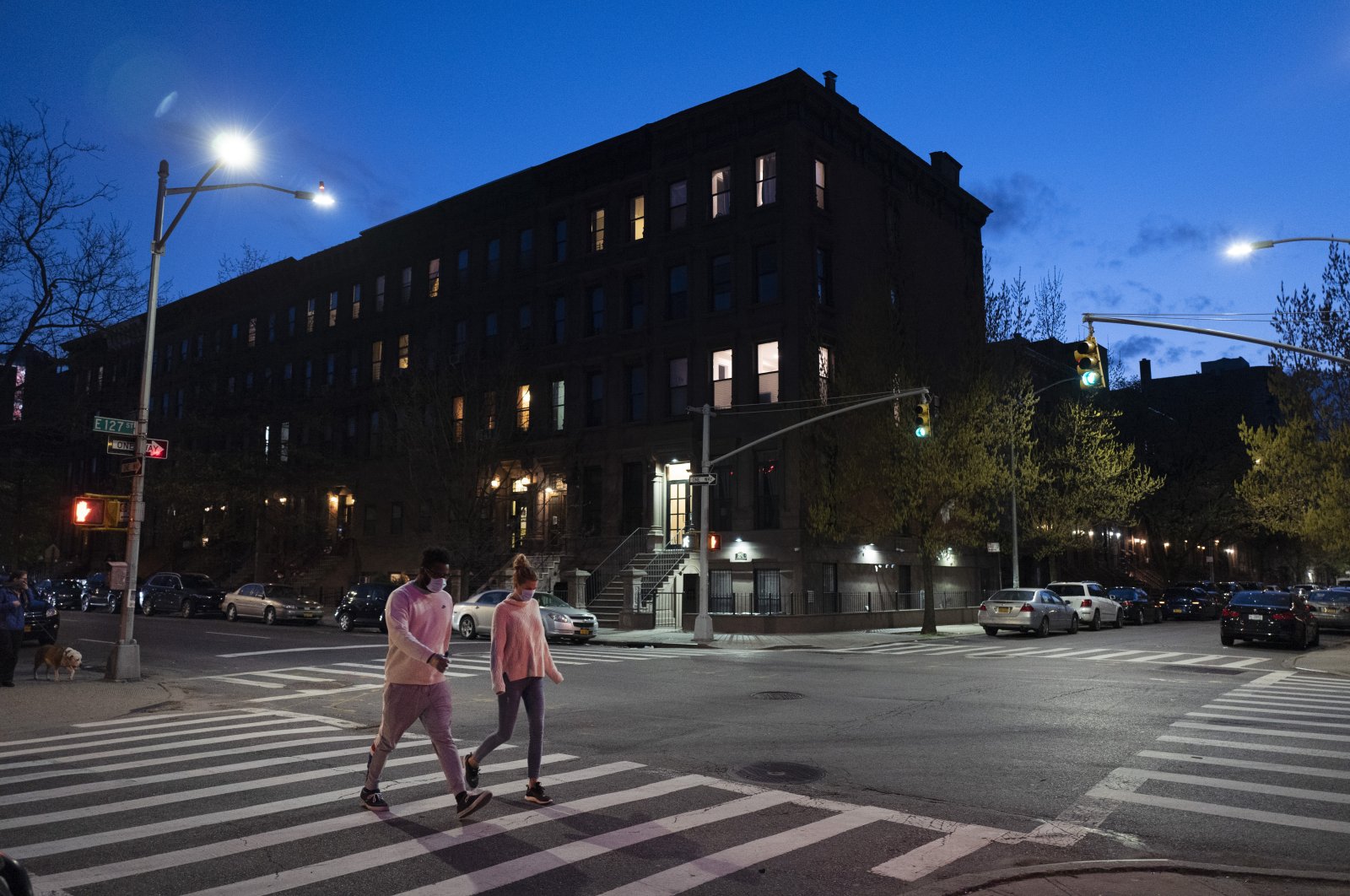 People wearing masks cross the street at Langston Hughes Place in Harlem during the coronavirus pandemic, in New York City, New York, U.S., April 15, 2020. (AP Photo)