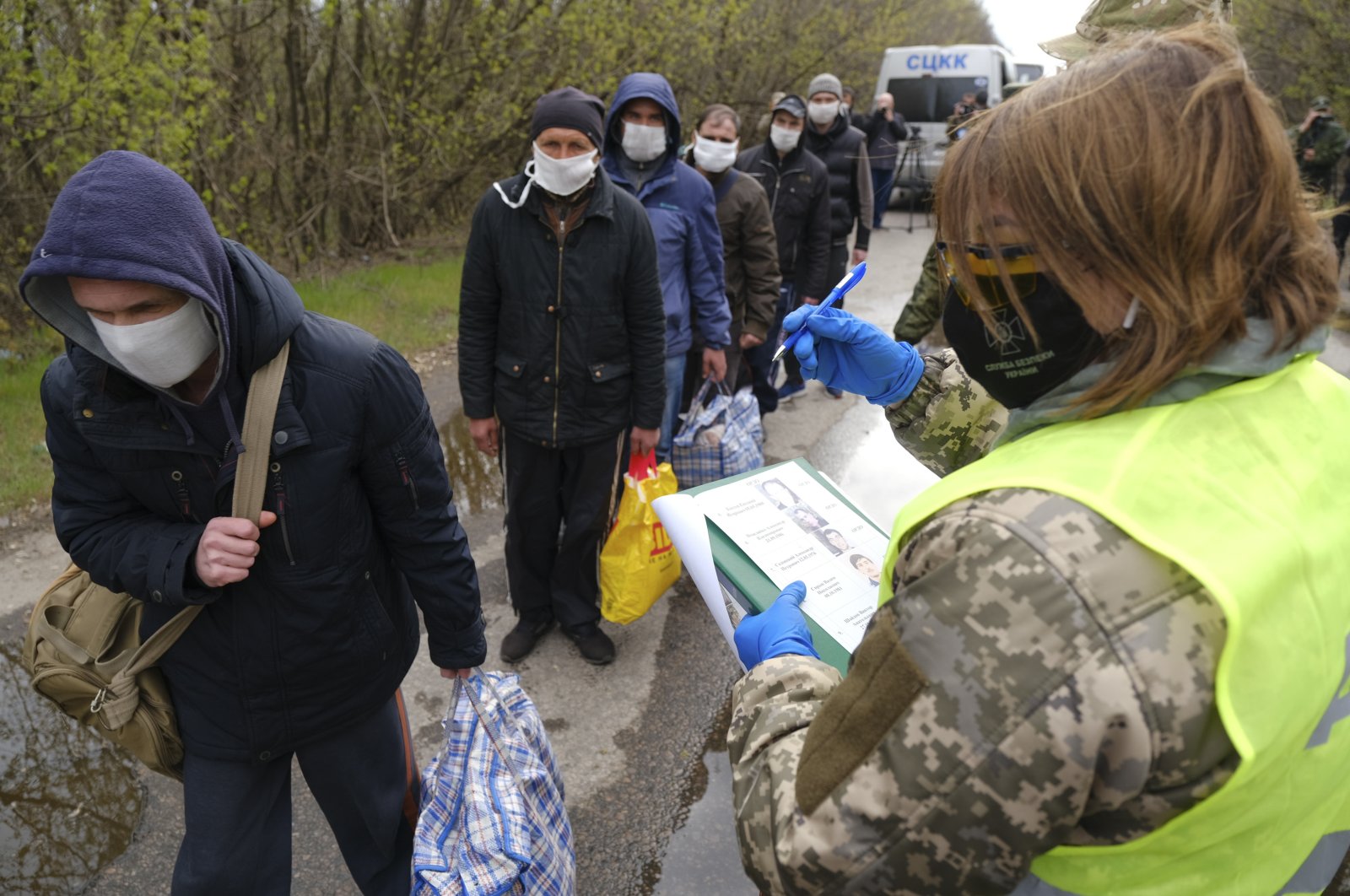 Russia-backed separatists war prisoners wearing masks to protect against coronavirus walk during a prisoner exchange, near Gorlivka, Donetsk region, eastern Ukraine, April 16, 2020. (AP Photo)