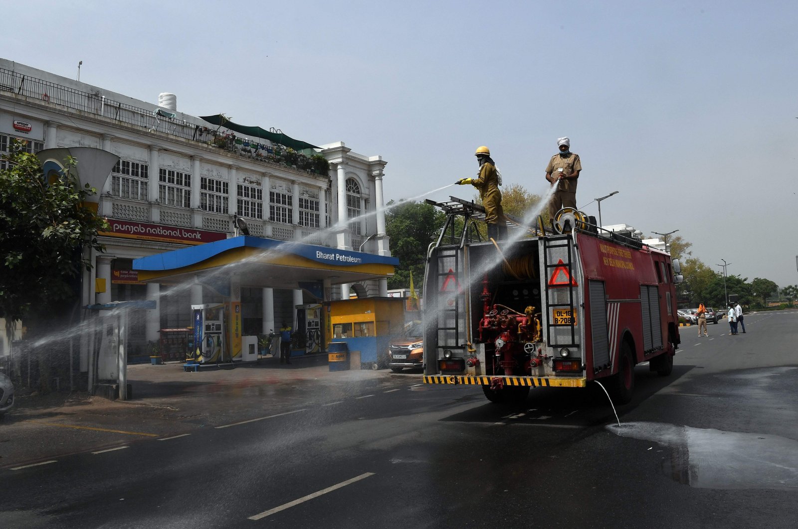 Delhi Fire Service (DFS) personnel spray disinfectant chemicals along a road during a government-imposed nationwide lockdown as a preventive measure against the COVID-19 coronavirus in New Delhi on April 16, 2020. (AFP Photo)