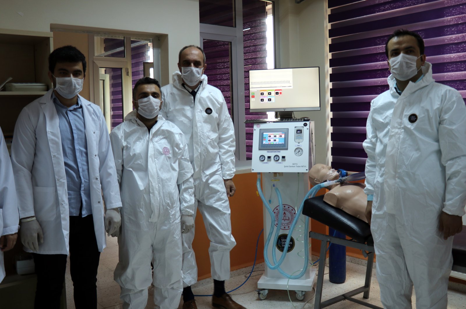 Staff and students of Şehit Serkan Talan Vocational and Technical High School pose with a ventilator device, Hatay, Turkey, April 16, 2020. (AA Photo)