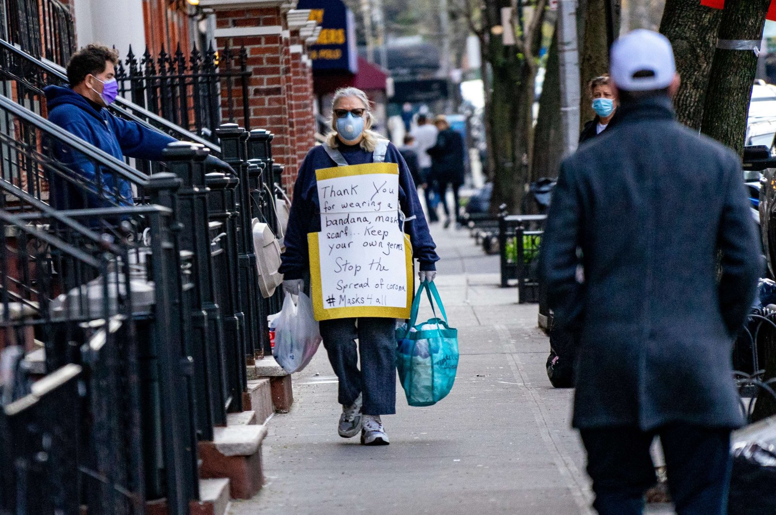 A person walks down a street with a sign thanking people for wearing face coverage on April 15, 2020, in New York City. (AFP Photo)