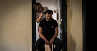 Lucie cuts her companion Pierre's hair at home as coiffeurs stay closed on the 25th day of a strict lockdown aimed at curbing the spread of COVID-19, Paris, April 10, 2020. (Photo by Elena FUSCO / AFP)