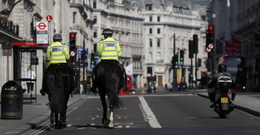 Mounted police officers patrol along a deserted Regent Street in London, as the U.K. is in lockdown to help curb the spread of the coronavirus, April 15, 2020. (AP Photo)