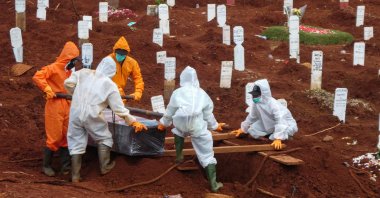 Workers move a coffin of a COVID-19 victim to a burial site at a cemetery in Jakarta, Indonesia, April 15, 2020. (AFP Photo)