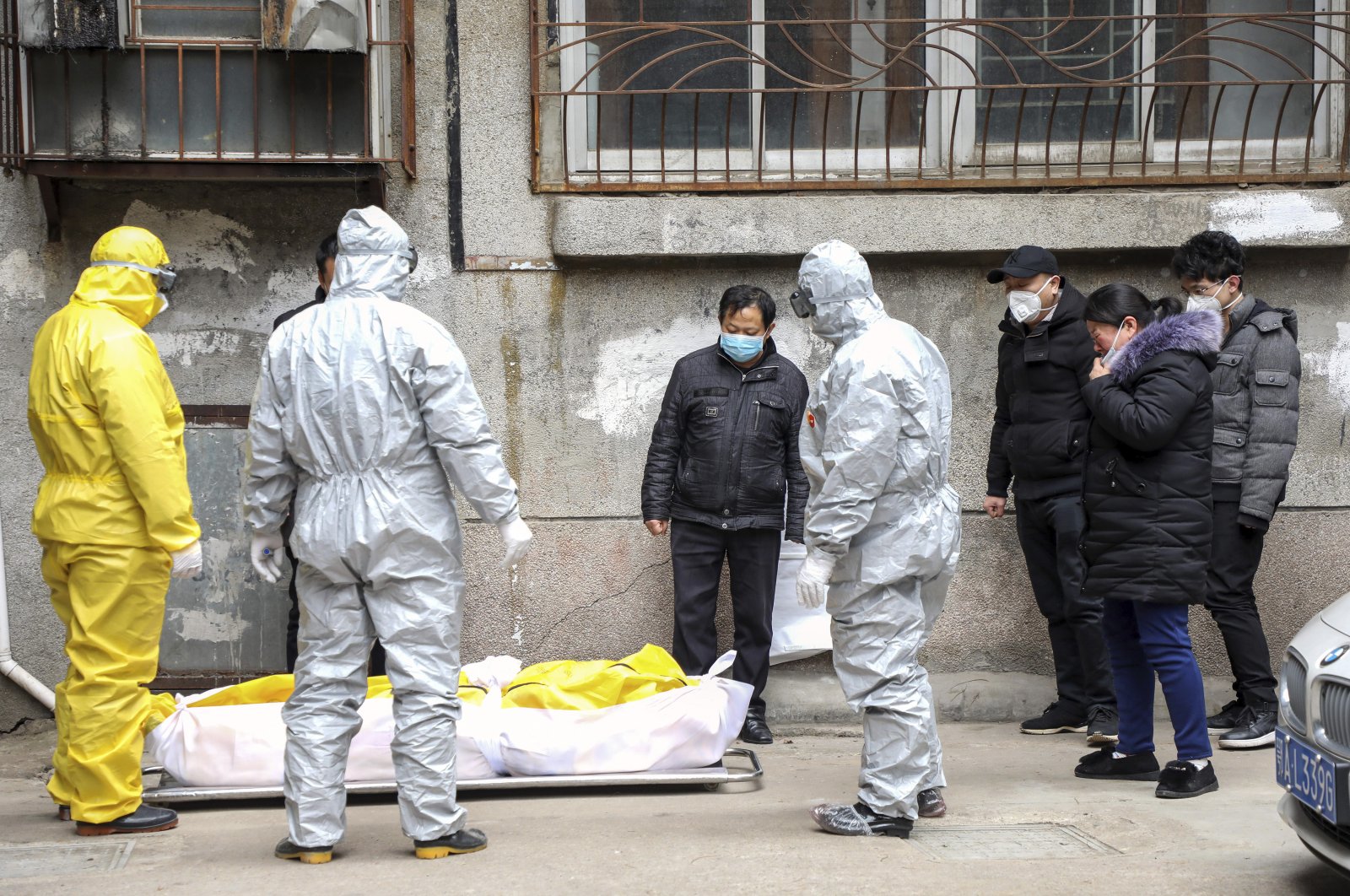 Funeral home workers remove the body of a person suspected to have died during the coronavirus outbreak from a residential building in Wuhan in central China's Hubei Province, Feb. 1, 2020. (Chinatopix via AP)