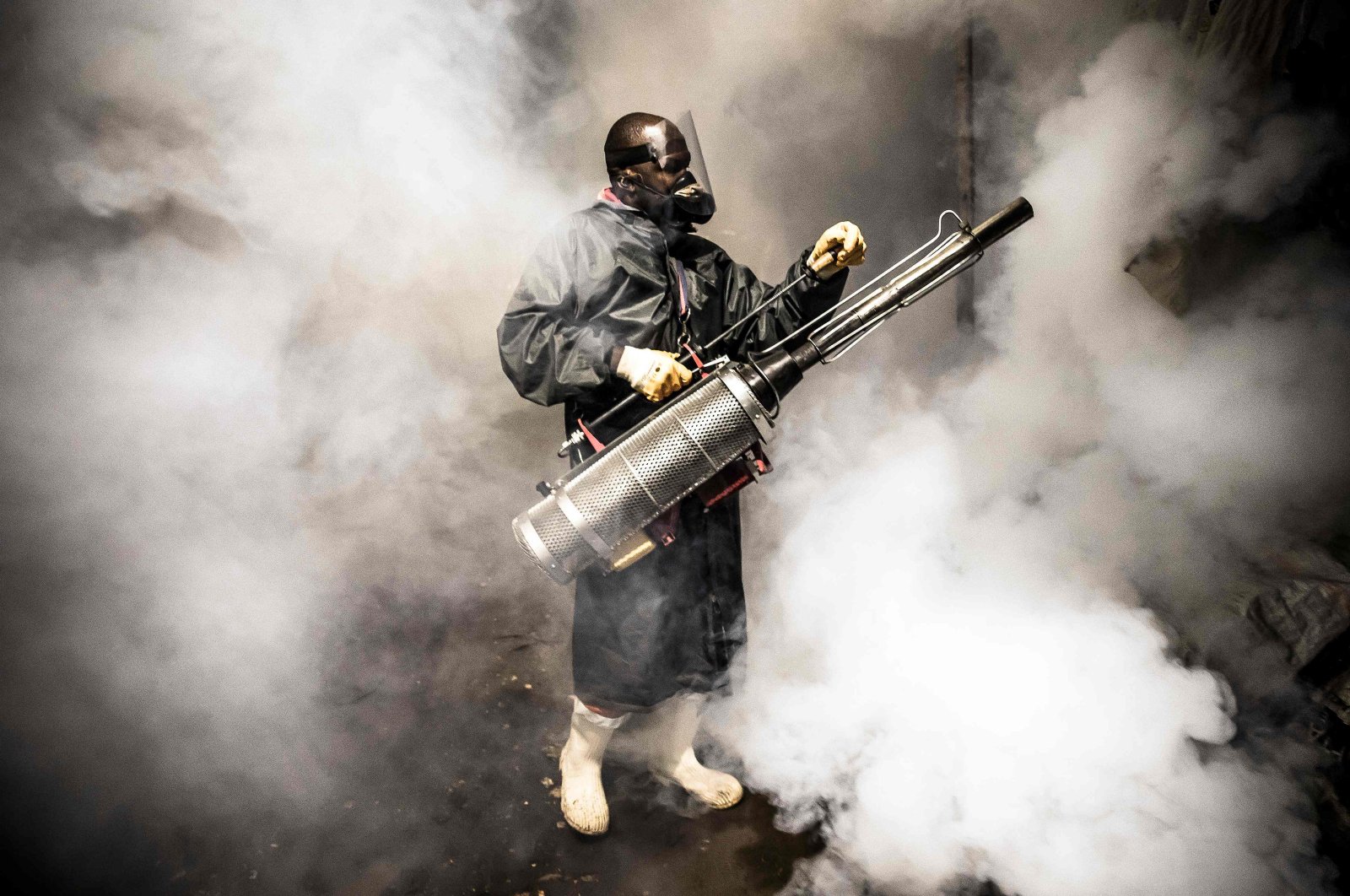 A member of a privately funded nongovernmental organization fumigates and disinfects streets and the stalls at Parklands City Park Market to help curb the spread of COVID-19, Nairobi, Kenya, April 15, 2020. (AFP Photo)