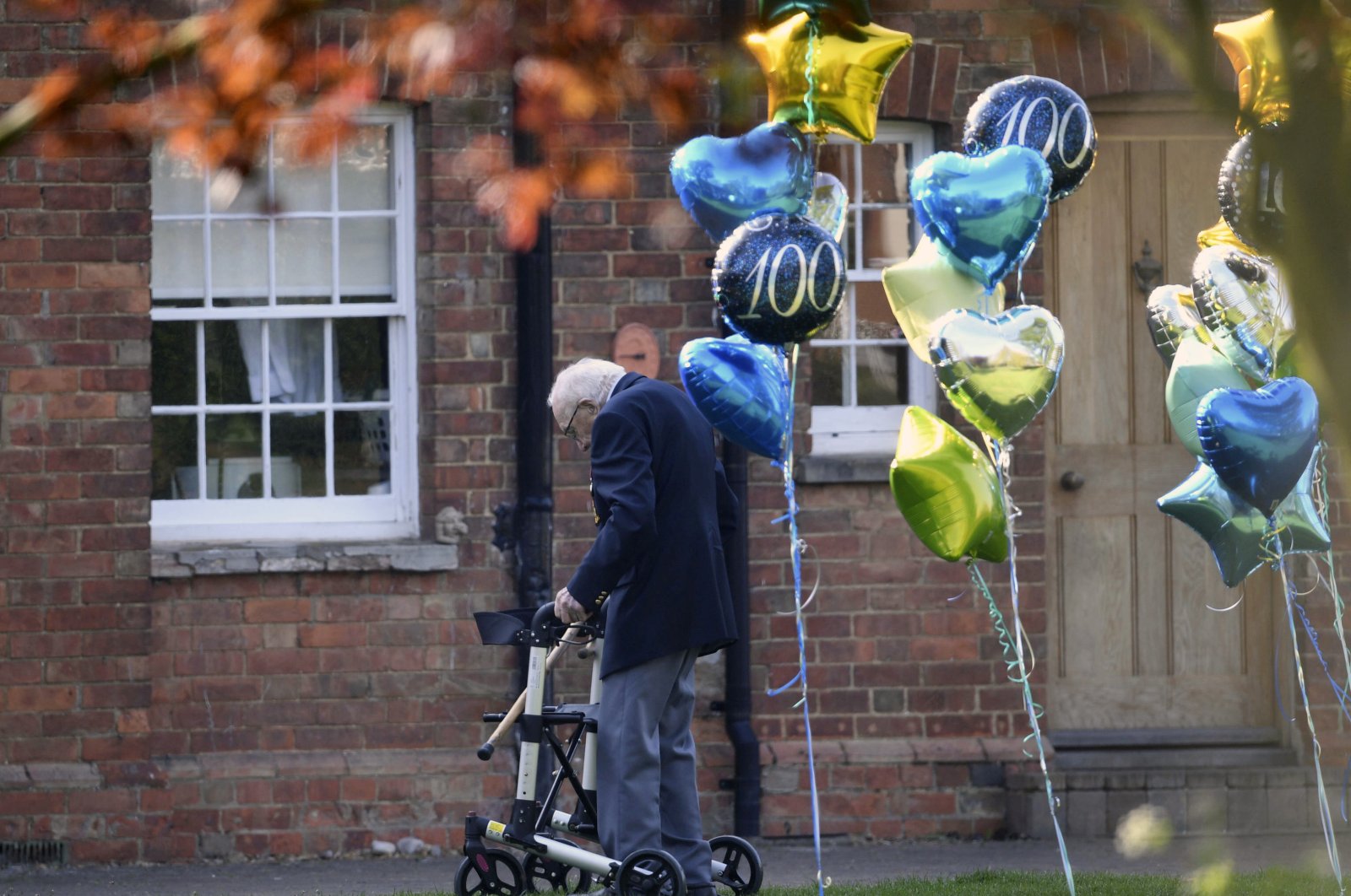 99-year old British military veteran Tom Moore, who has completed the 100th length of his garden at his home in Marston Moretaine, raising millions of pounds for the NHS with donations to his fundraising challenge from around the world, Thursday April 16, 2020. (AP Photo)