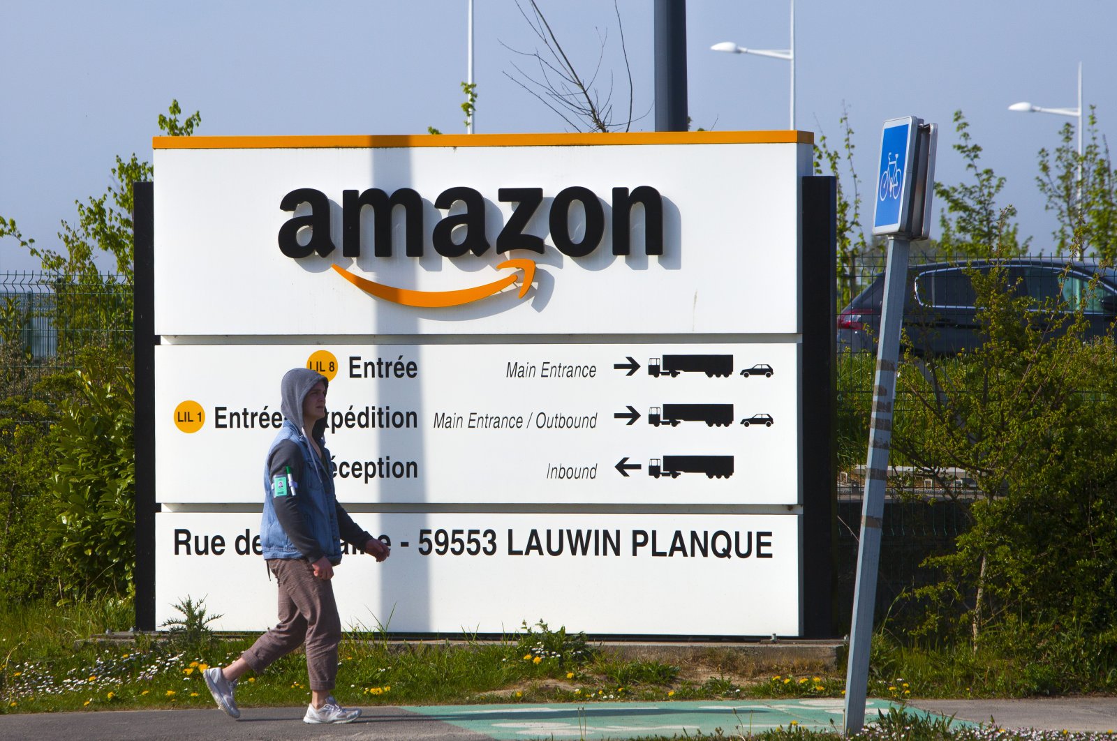 A man walks at the entrance of Amazon, in Douai, northern France, April 16, 2020. (AP Photo)