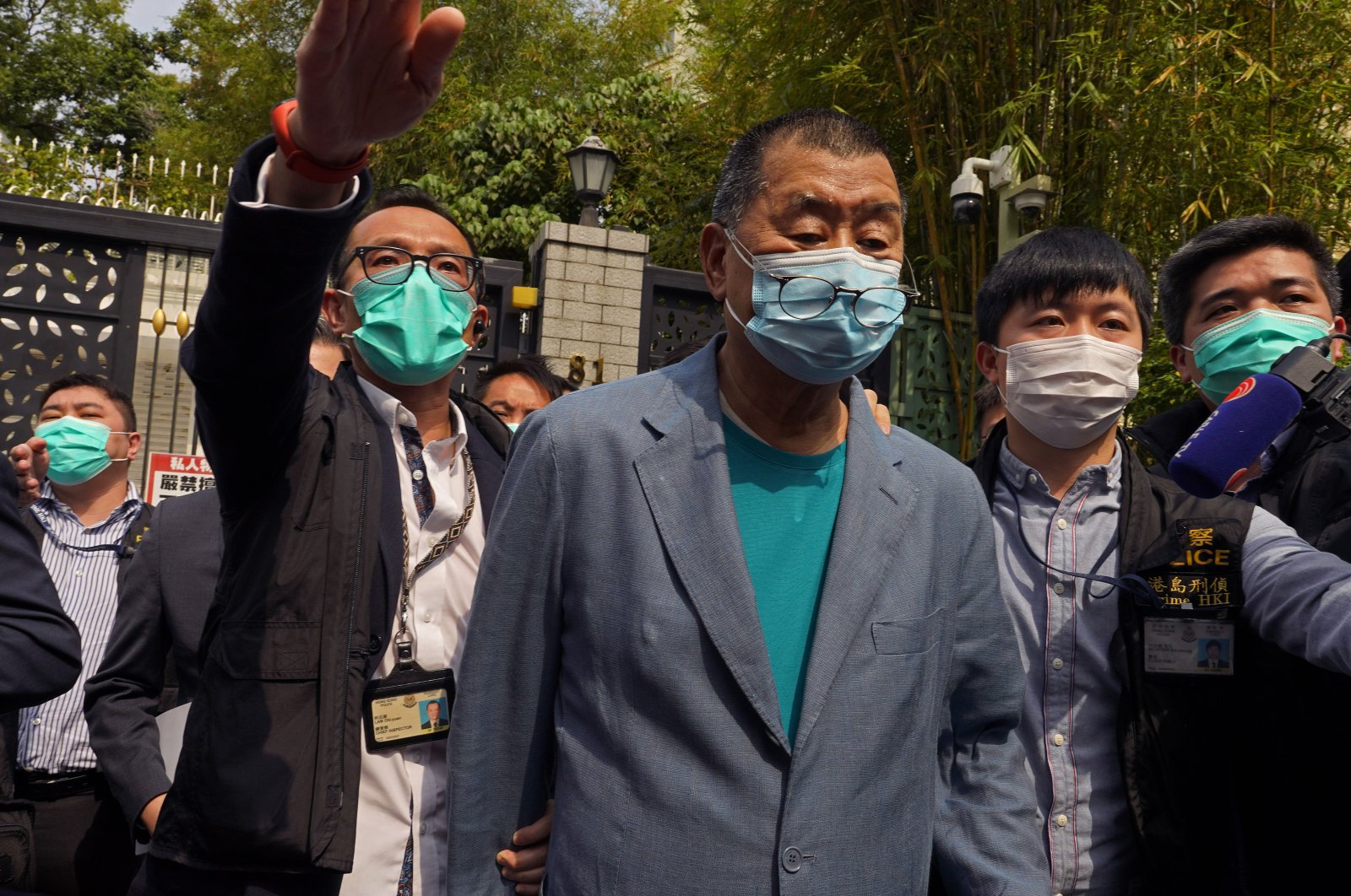 Hong Kong media tycoon Jimmy Lai, center, who founded local newspaper Apple Daily, is arrested by police officers at his home in Hong Kong, Saturday, April 18, 2020. (AP Photo)