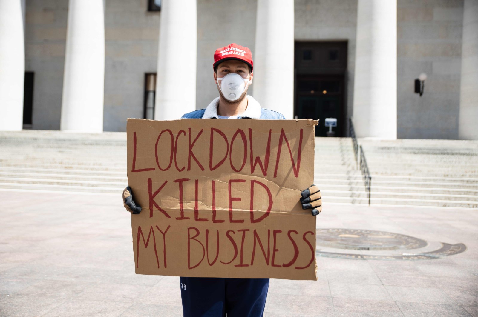 A protester holds a sign outside the Ohio Statehouse in Columbus, Ohio on April 18, 2020, to protest the stay-home order in effect until May 1. (AFP Photo)