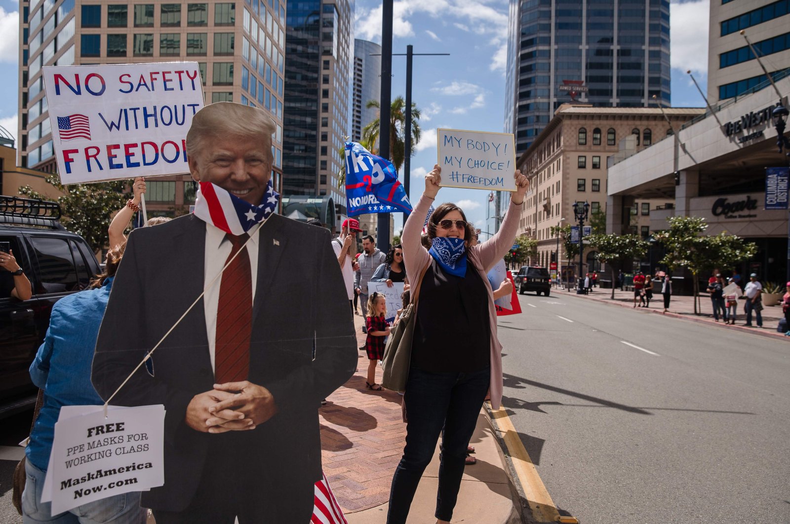 A Trump cutout with a US flag around its neck is seen next to protesters rallying in downtown San Diego against California's stay at home order to prevent the spread of the novel coronavirus, which causes COVID-19, on April 18, 2020. (AFP Photo)
