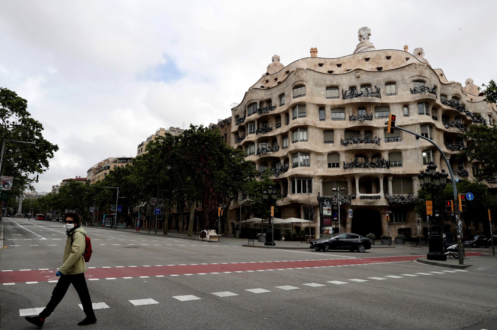 A man promenades with his dog in front of Pedrera's bulding by Guadi at Paseo de Gracia street in an empty Barcelona, Spain,18 April 2020, during the coronavirus crisis. (EPA-EFE/Toni Albir Photo)