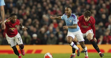 Manchester City's Raheem Sterling (C) and Manchester United's Victor Lindelof (R) compete for the ball during a Premier League match in Manchester, England, March 8, 2020. (AP Photo)