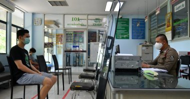 Citizens and police officers wearing protective face masks due to the coronavirus disease (COVID-19) outbreak keep social distance at a police station in Bangkok, Thailand, March 28, 2020. (Reuters Photo)