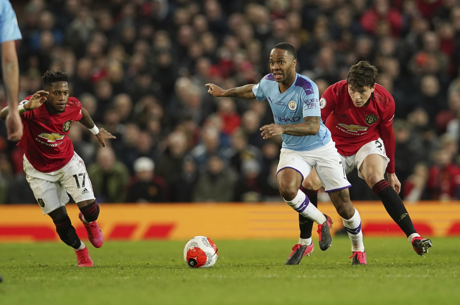 Manchester City's Raheem Sterling (C) and Manchester United's Victor Lindelof (R) compete for the ball during a Premier League match in Manchester, England, March 8, 2020. (AP Photo)
