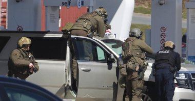 In this April 19, 2020, file photo, Royal Canadian Mounted Police officers surround a suspect at a gas station in Enfield, Nova Scotia. Canadian police say multiple people are dead plus the suspect after a shooting rampage across the province of Nova Scotia. (Tim Krochak/The Canadian Press via AP)