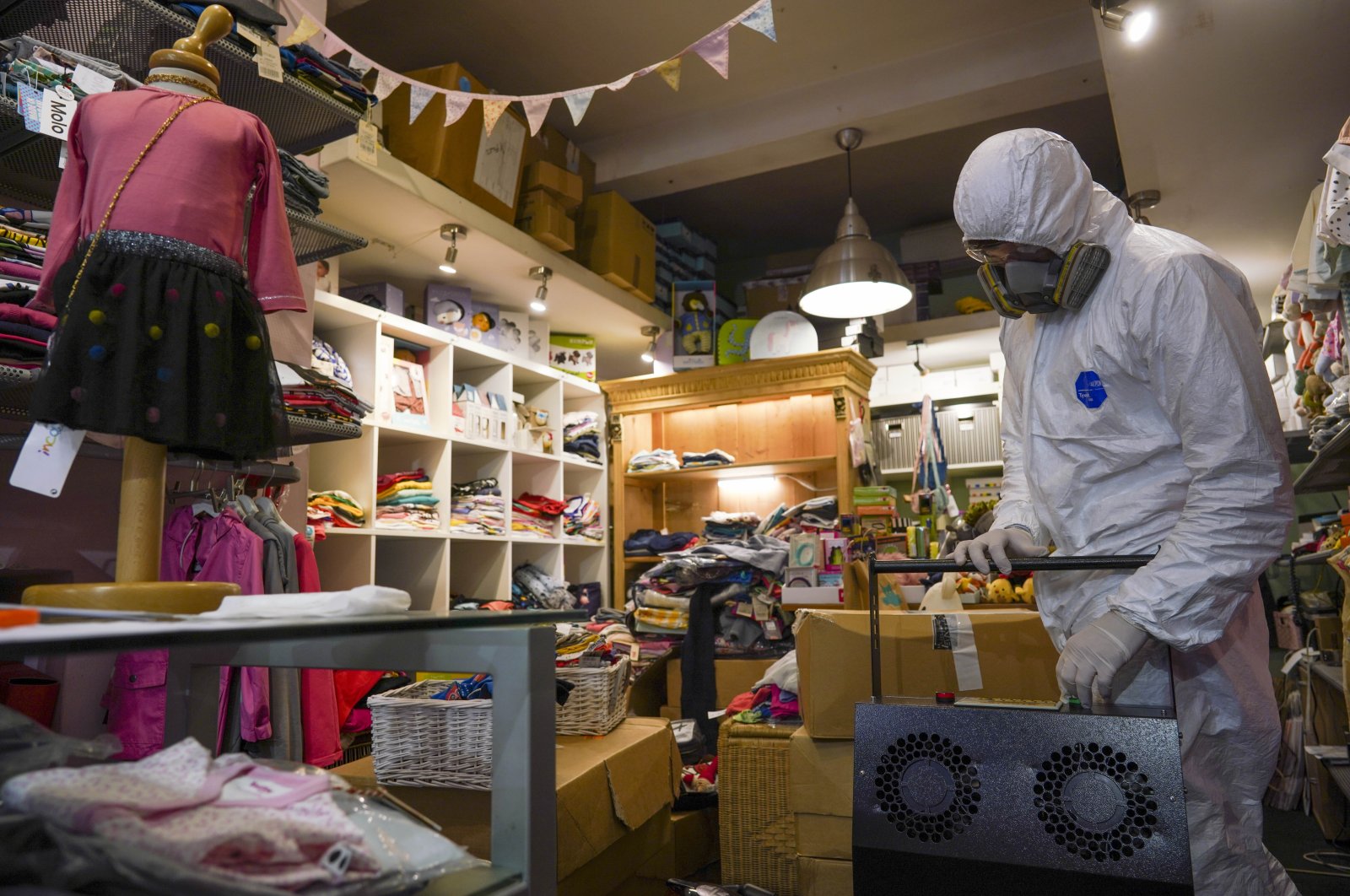 A man in protective gear prepares to sanitize a children's clothes shop before it opens to prevent the spread of COVID-19, in Rome, Italy, April 14, 2020. (AP Photo)