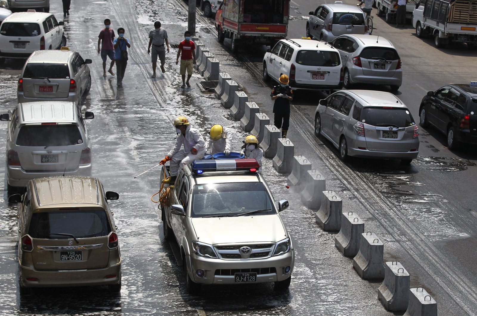 The fire department spray disinfectant to help curb the spread of the new coronavirus on a road Tuesday, April 21, 2020, in Yangon, Myanmar. (AP Photo)
