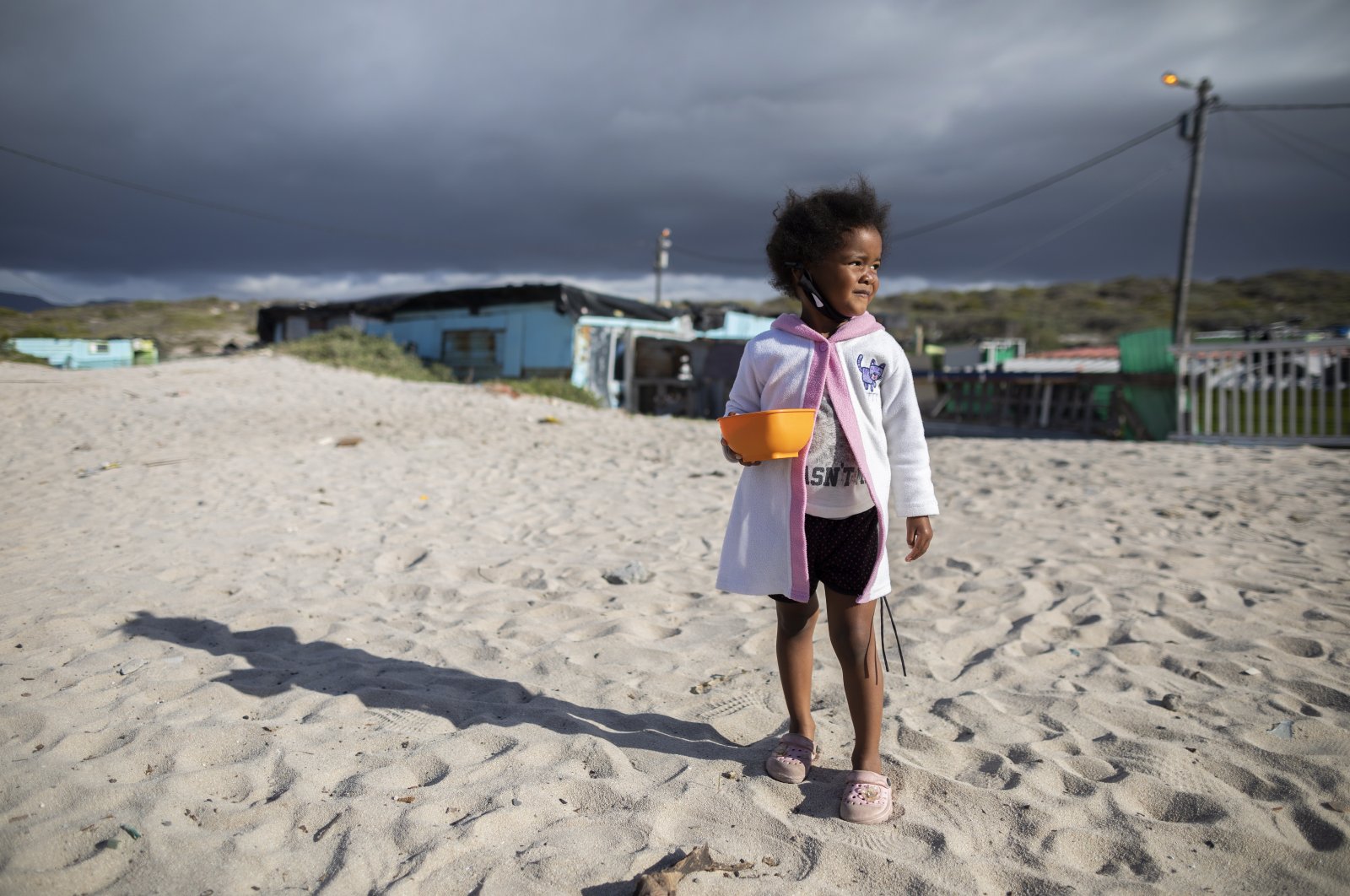 A girl from the 7de Laan shack settlement waits for food from the 9 Miles Project COVID-19 community support program in Strandfontein, Cape Town, South Africa, April 20, 2020. (EPA Photo)