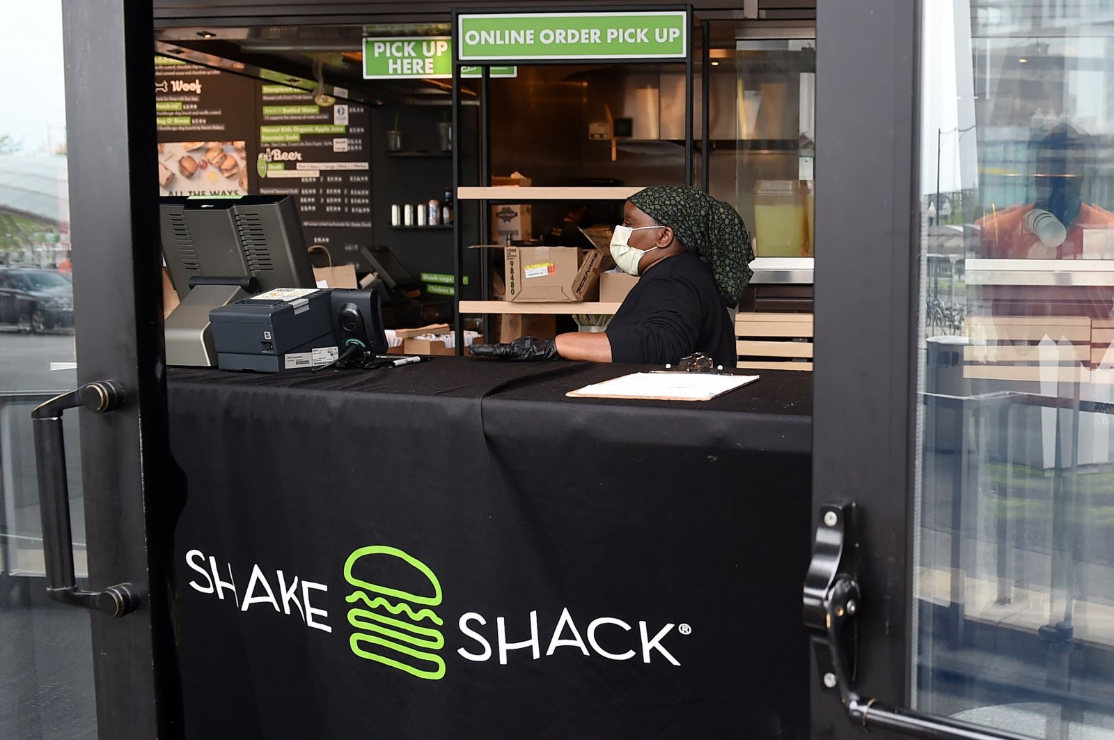 A Shake Shack employee wears a masks as she prepares food orders for pickup during the coronavirus pandemic, in Arlington, Virginia, U.S., April 20, 2020. (AFP Photo)