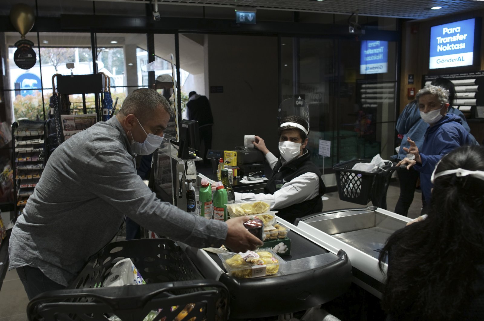 People wearing face masks shop for food at a market, in Ankara Turkey, Tuesday, April 21, 2020, two days before the start of a four-day curfew declared by the government in an attempt to control the spread of coronavirus. (AP Photo)