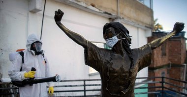 A volunteer disinfects the statue of US singer Michael Jackson, at the Santa Marta favela in Rio de Janeiro, Brazil, during the COVID-19 coronavirus pandemic on April 20, 2020. (AFP Photo)