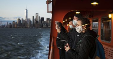 A group of emergency medical technicians who have come to New York to assist ambulance crews during the coronavirus pandemic ride the Staten Island Ferry, in New York, April 21, 2020. (AP Photo)