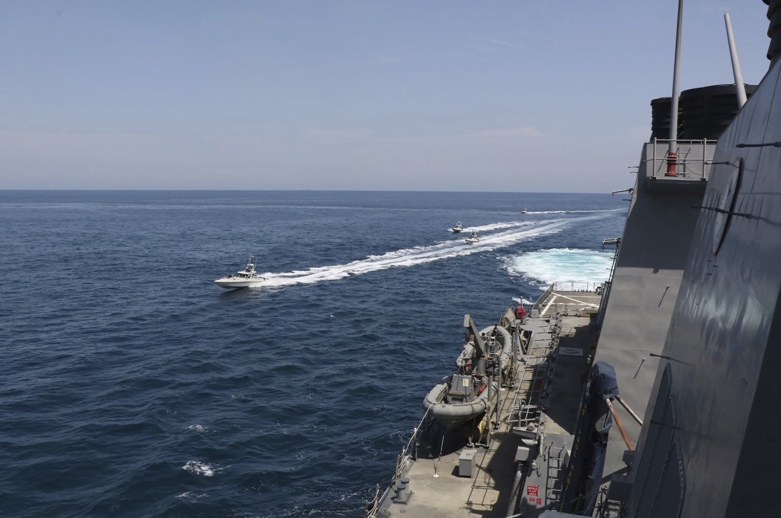 In this Wednesday, April 15, 2020, photo made available by U.S. Navy, Iranian Revolutionary Guard vessels sail close to U.S. military ships in the Persian Gulf near Kuwait. (U.S. Navy via AP)