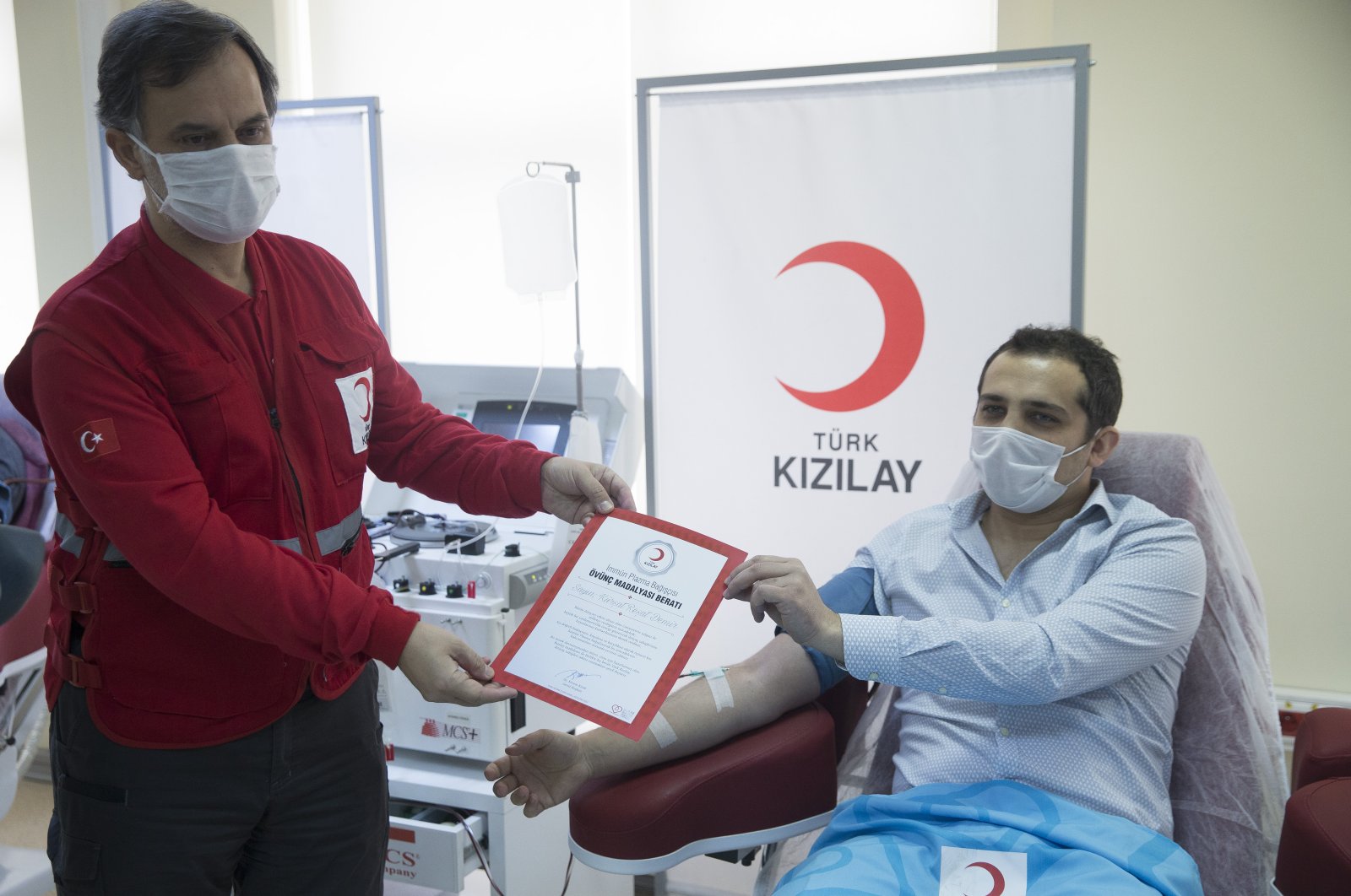 Dr. Kürşat Reşat Demir receives his medal from İbrahim Altan, general director of the Turkish Red Crescent, in Ankara, April 21, 2020. (AA Photo)