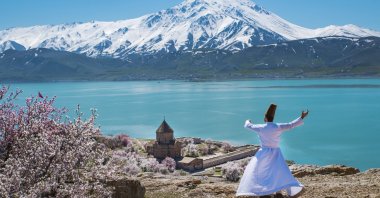 A whirling dervish performs a show near the Akdamar Church in the eastern province of Van, Turkey, in this undated photo. (İHA Photo)
