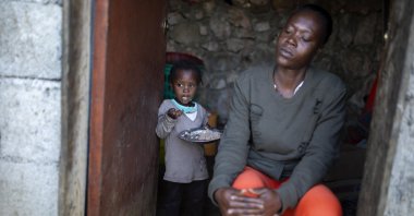 Two-year-old Badinal St. Juste eats rice behind her mother Tania Caristan at their home in Kenscoff, on the outskirts of Port-au-Prince, Haiti, March 9, 2020. (AP Photo)
