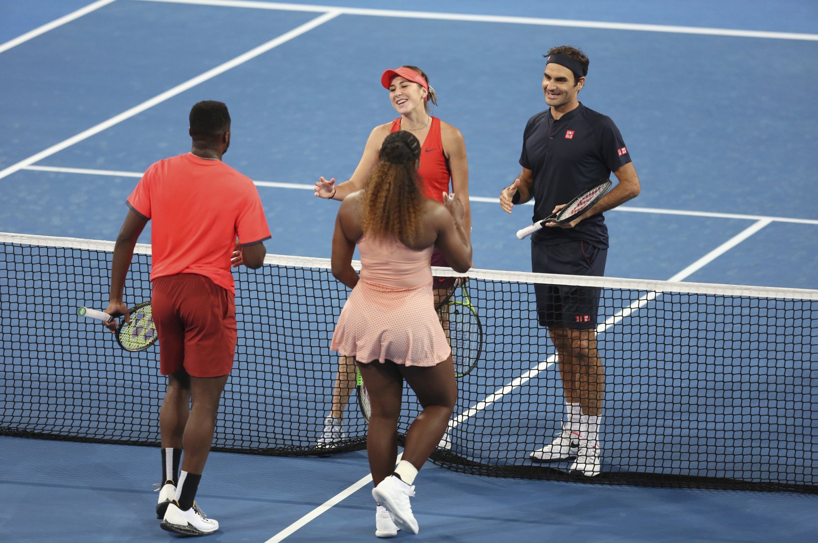 Roger Federer and Belinda Bencic wait at the net after winning their mixed doubles match against Frances Tiafoe and Serena Williams the Hopman Cup in Perth, Australia, Jan. 1, 2019. (AP Photo)