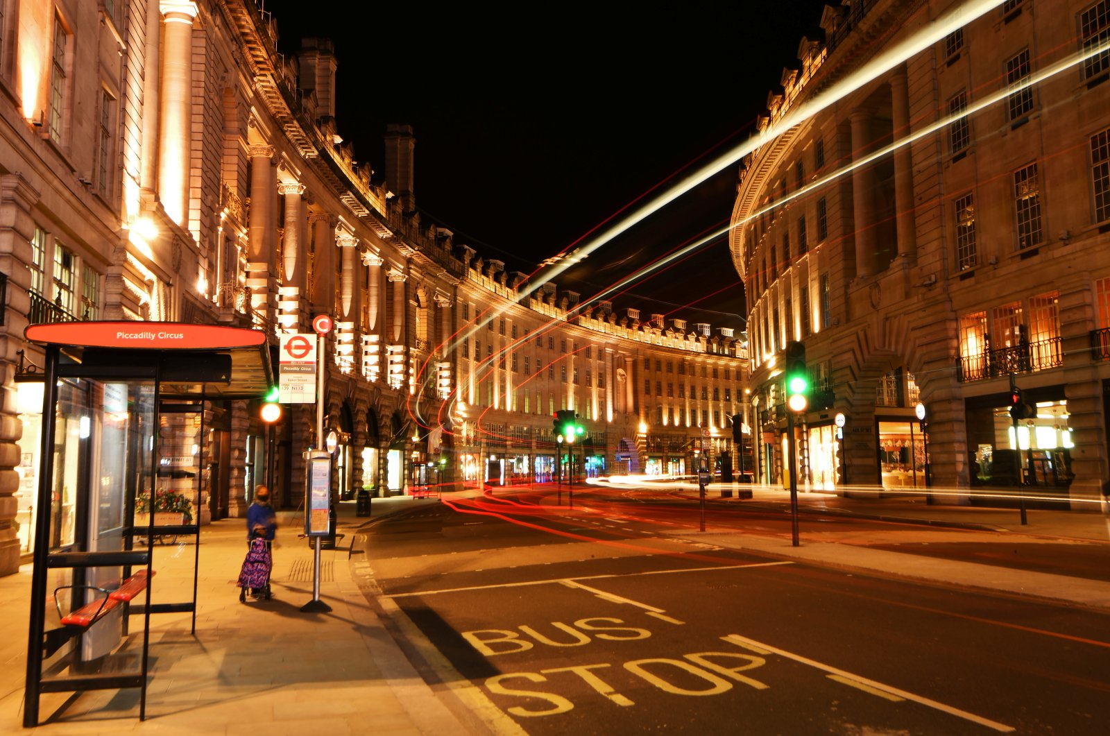 A woman waits for a bus on a quiet Regents Street during the late evening, as the city at night is deserted like never before while the coronavirus disease (COVID-19) lockdown continues, in London, Britain April 21, 2020. (Reuters Photo)