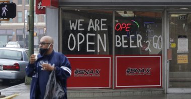 A man wears a face mask as he leaves a business that remains open in downtown San Antonio, Texas, Wednesday, April 22, 2020. (AP Photo)