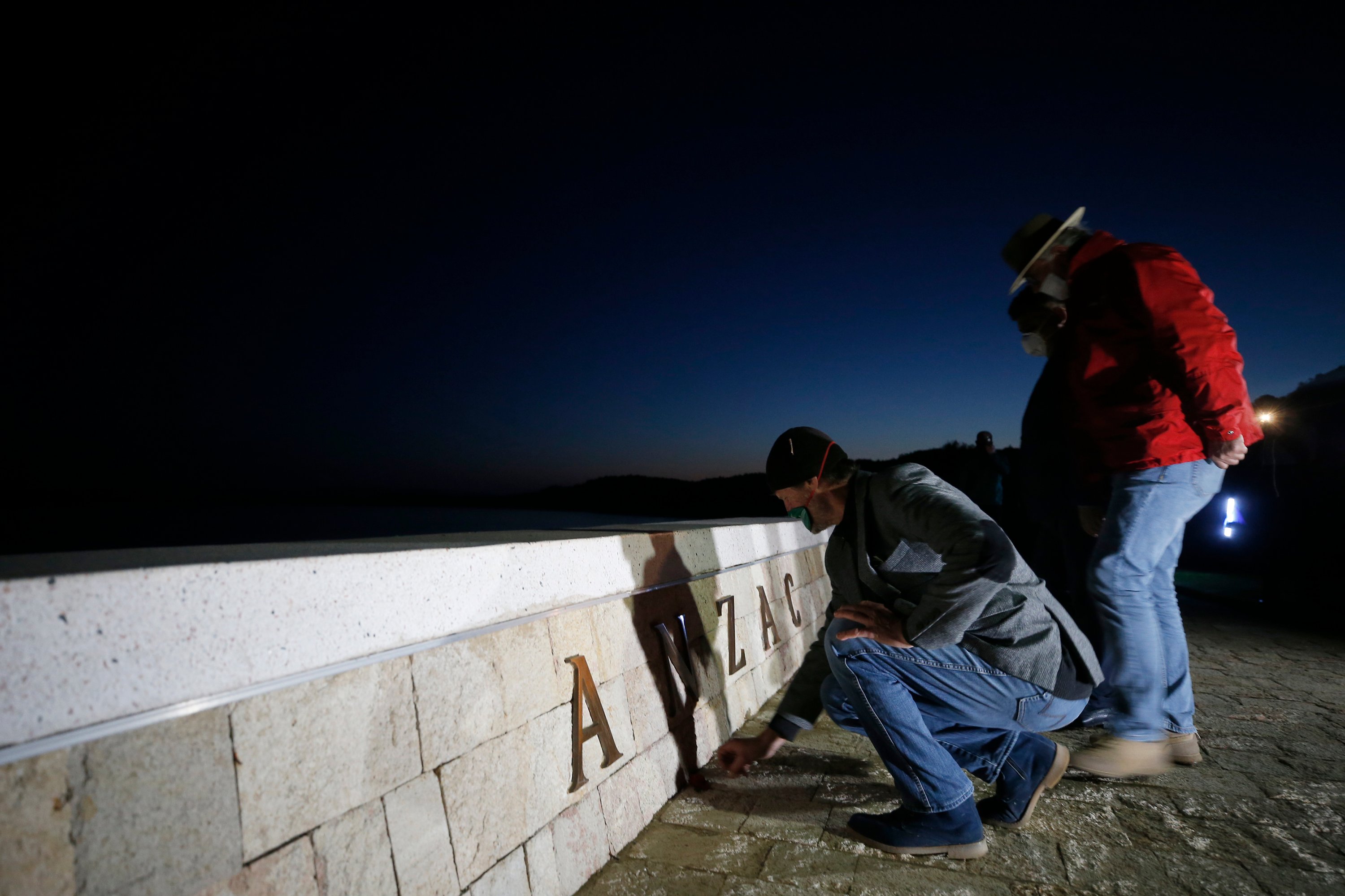 Employees of a local tourism company leave flowers at the Anzac Cove beach memorial. (AP Photo)