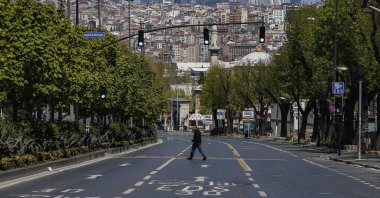 A man crosses a deserted road in Istanbul, during the first day of the holy fasting month of Ramadan, April 24, 2020. (AP Photo)