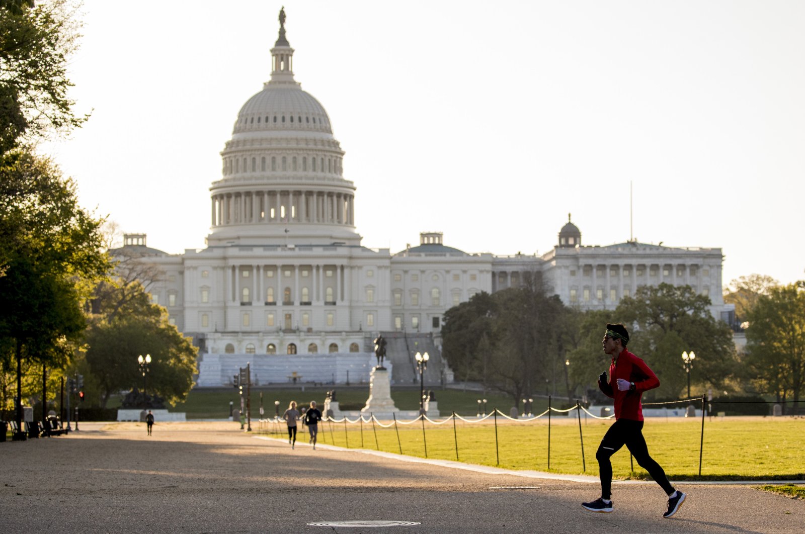 The United States Capitol is visible as a jogger crosses the National Mall, Washington D.C., U.S., April 22, 2020. (AP Photo)