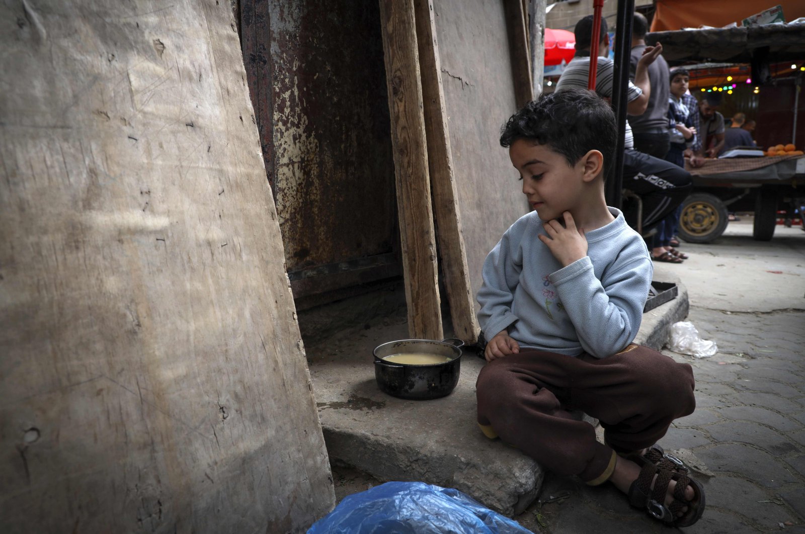 A Palestinian boy looks at his portion of soup, given out to poor families during the holy month of Ramadan, Gaza City, Palestine, April 24, 2020. (AFP Photo)