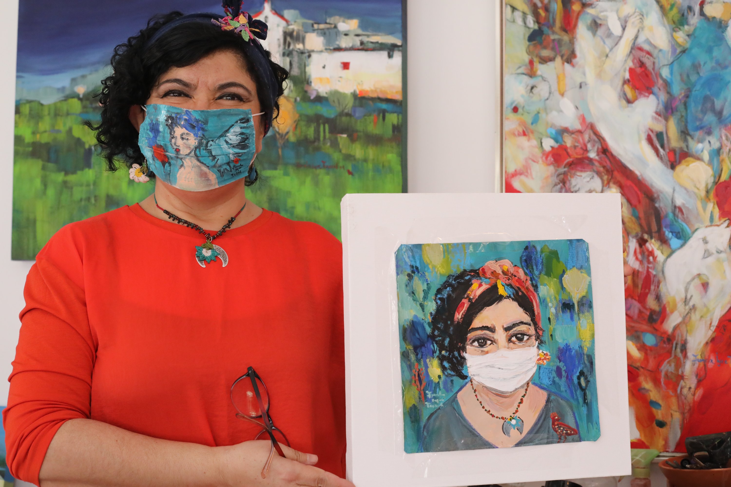 Artist Funda İyce Tuncel displays a self-portrait while wearing a mask she painted during the coronavirus pandemic, Ankara, Turkey, April 26, 2020. (AA Photo)