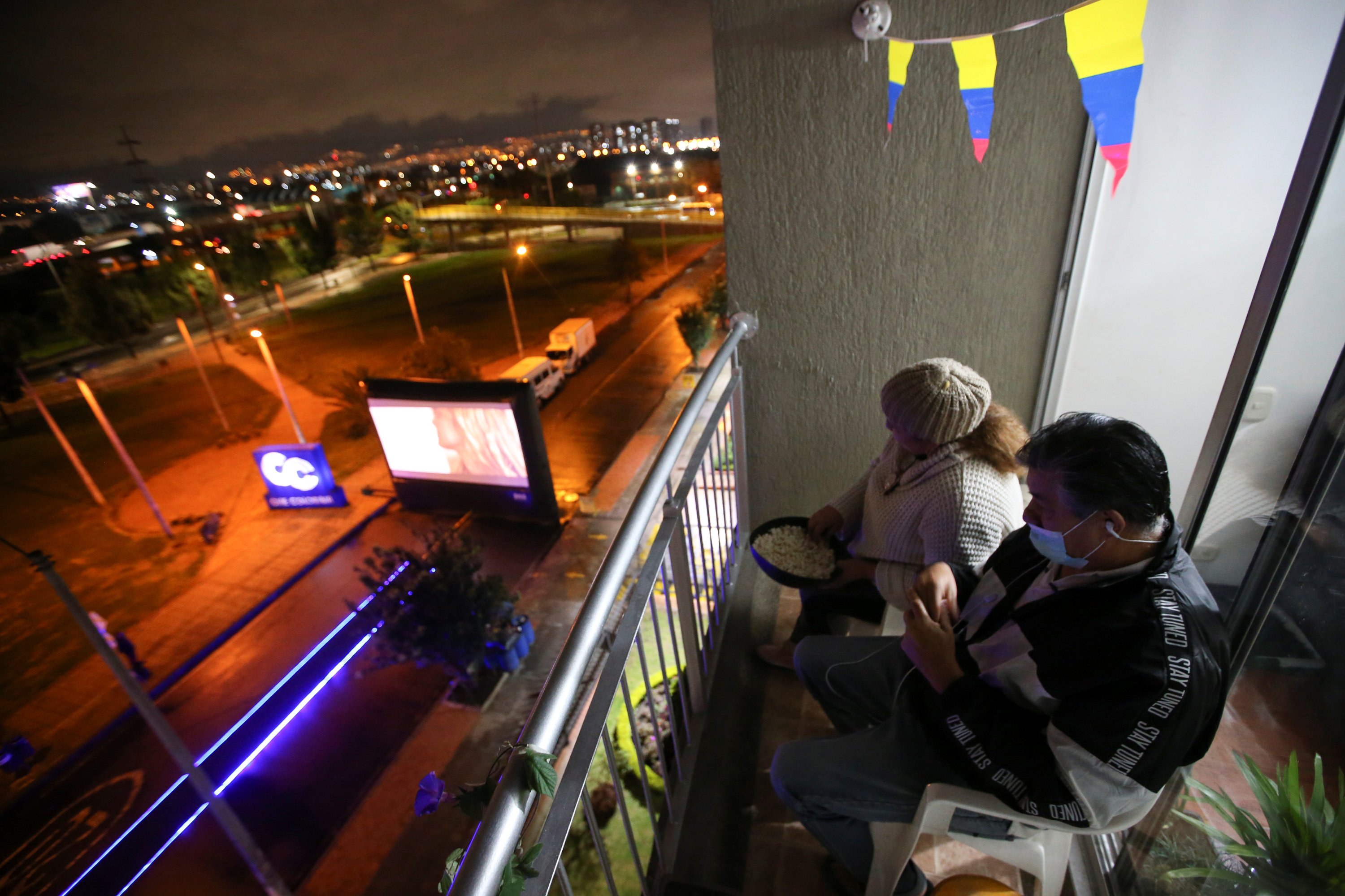 People watch a movie being shown on the street, from the balcony of their apartment, amid the outbreak of the coronavirus disease in Bogota, Colombia, April 22, 2020. (REUTERS Photo)