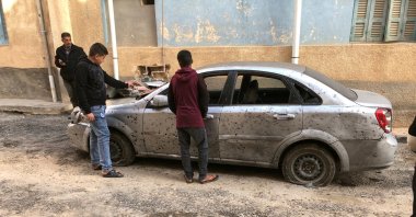 Libyan boys check a damaged car after a shell fell on a residential area of Hadba al-Badri district, in Tripoli, Libya, Jan. 28, 2020. (Reuters Photo)