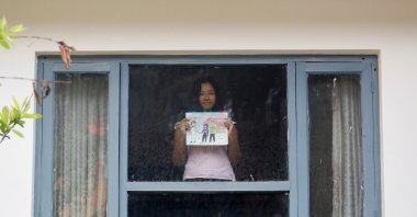 A girl poses for a photograph while holding a picture that she drew during the coronavirus outbreak, Kathmandu, Nepal, April 16, 2020. (REUTERS Photo)