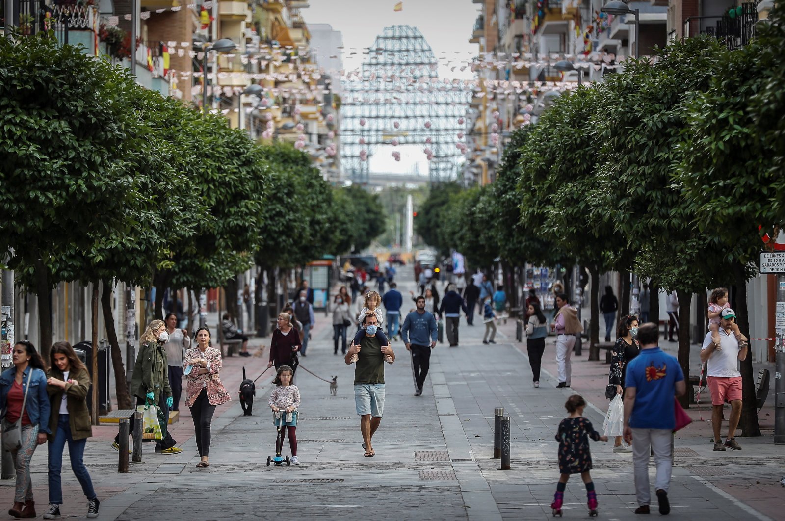 People walk down Callo San Jacinto, in Sevilla, Spain, April 26, 2020. (EPA Photo)